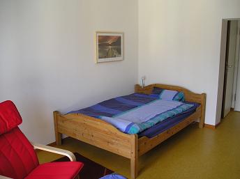 Bett, dahinter das Badezimmer